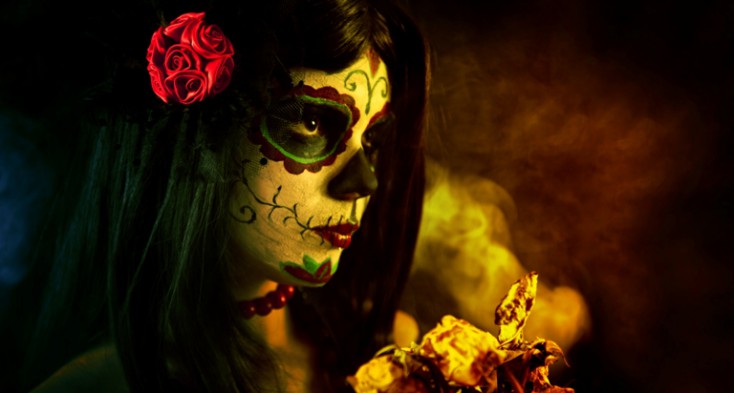 Artistic shot of sugar skull girl with dead roses © Depositphotos