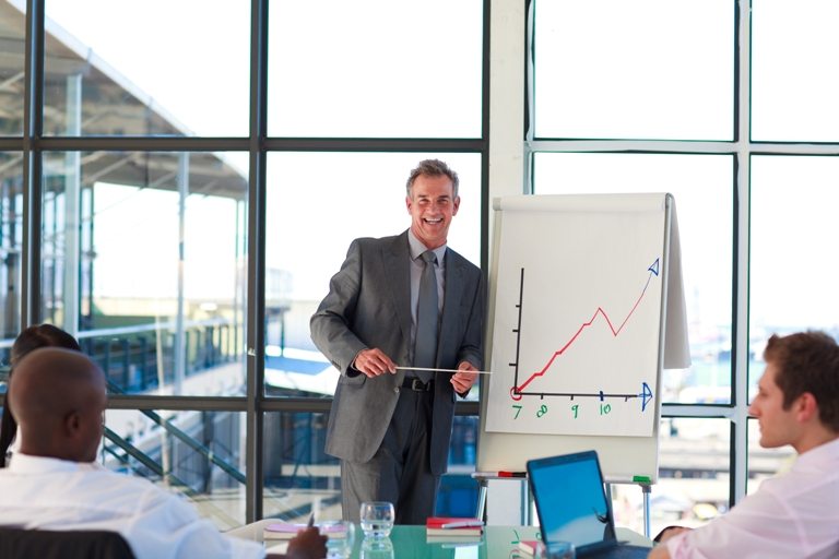 Mature businessman giving a presentation © Depositphotos