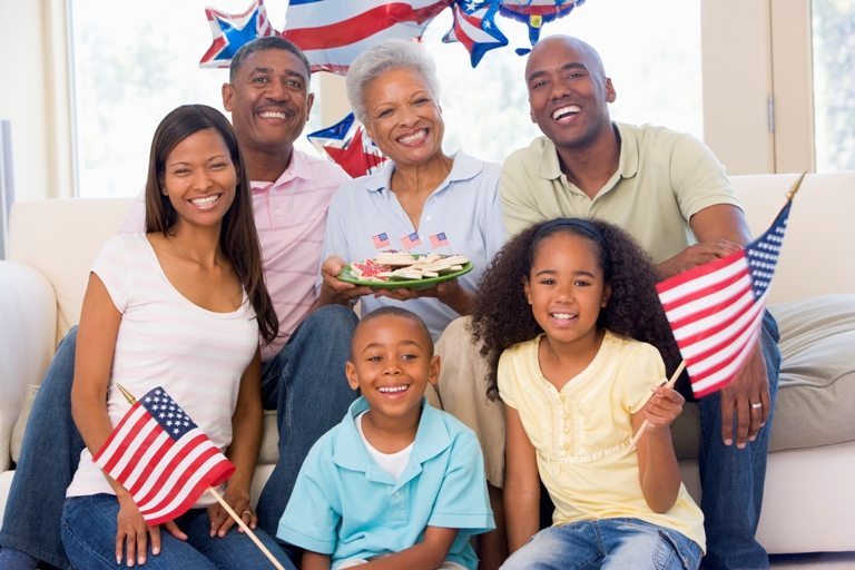 Family in living room on fourth of July with flags and cookies s © Depositphotos