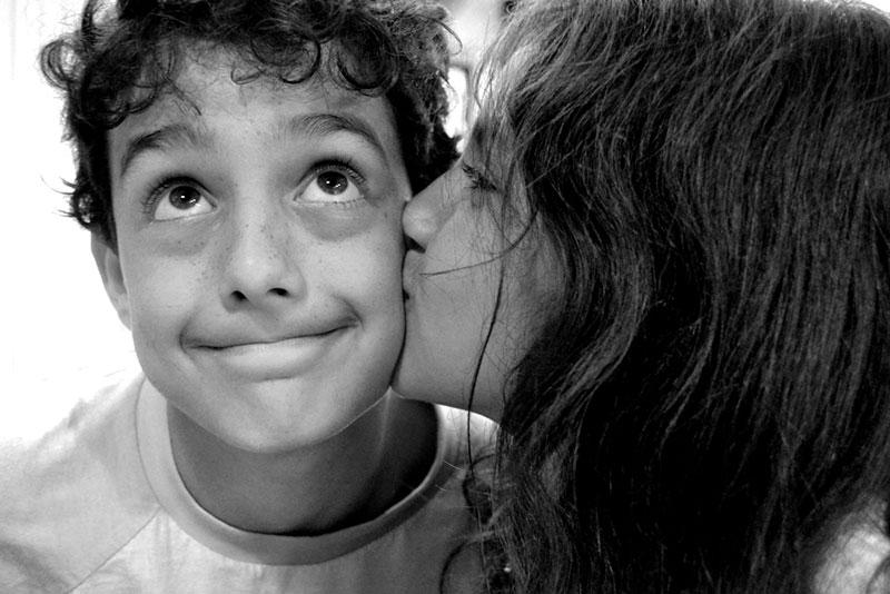 Close-up portrait of Girl kissing boy on the cheek