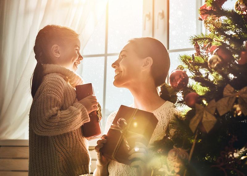 mother and daughter exchanging gifts on Christmas