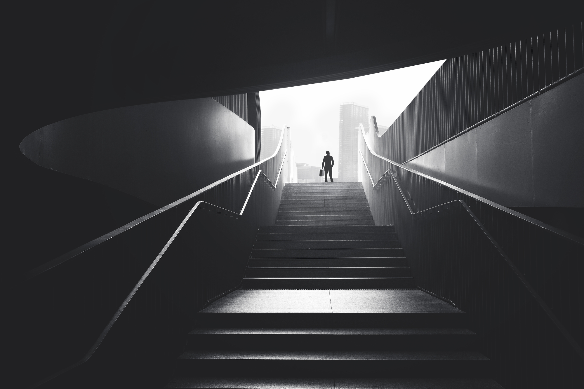 business man raising stairs to reach the city