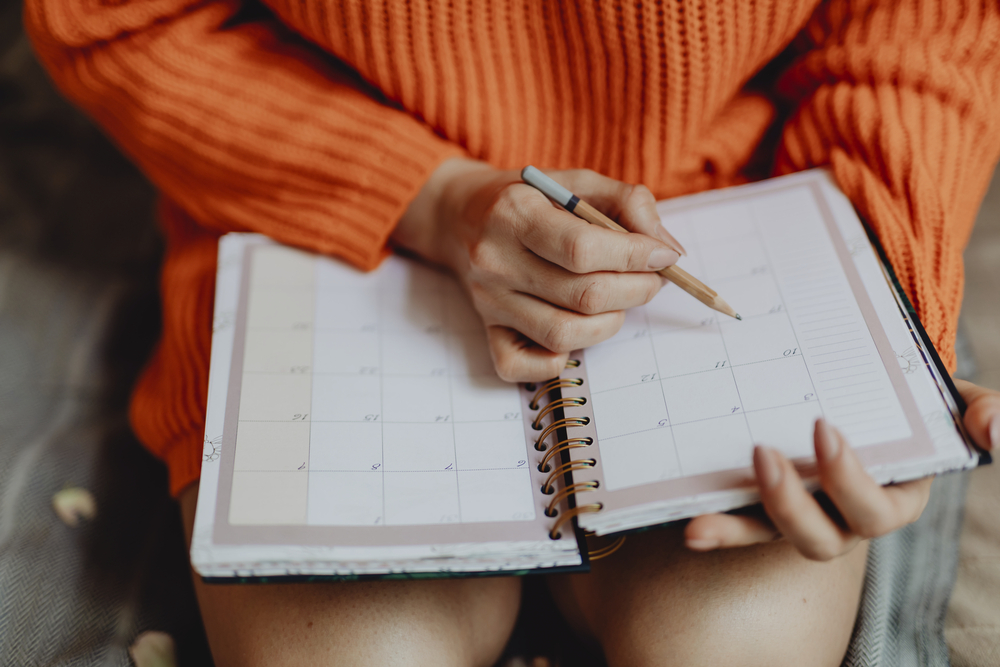 Woman writing in daily planner