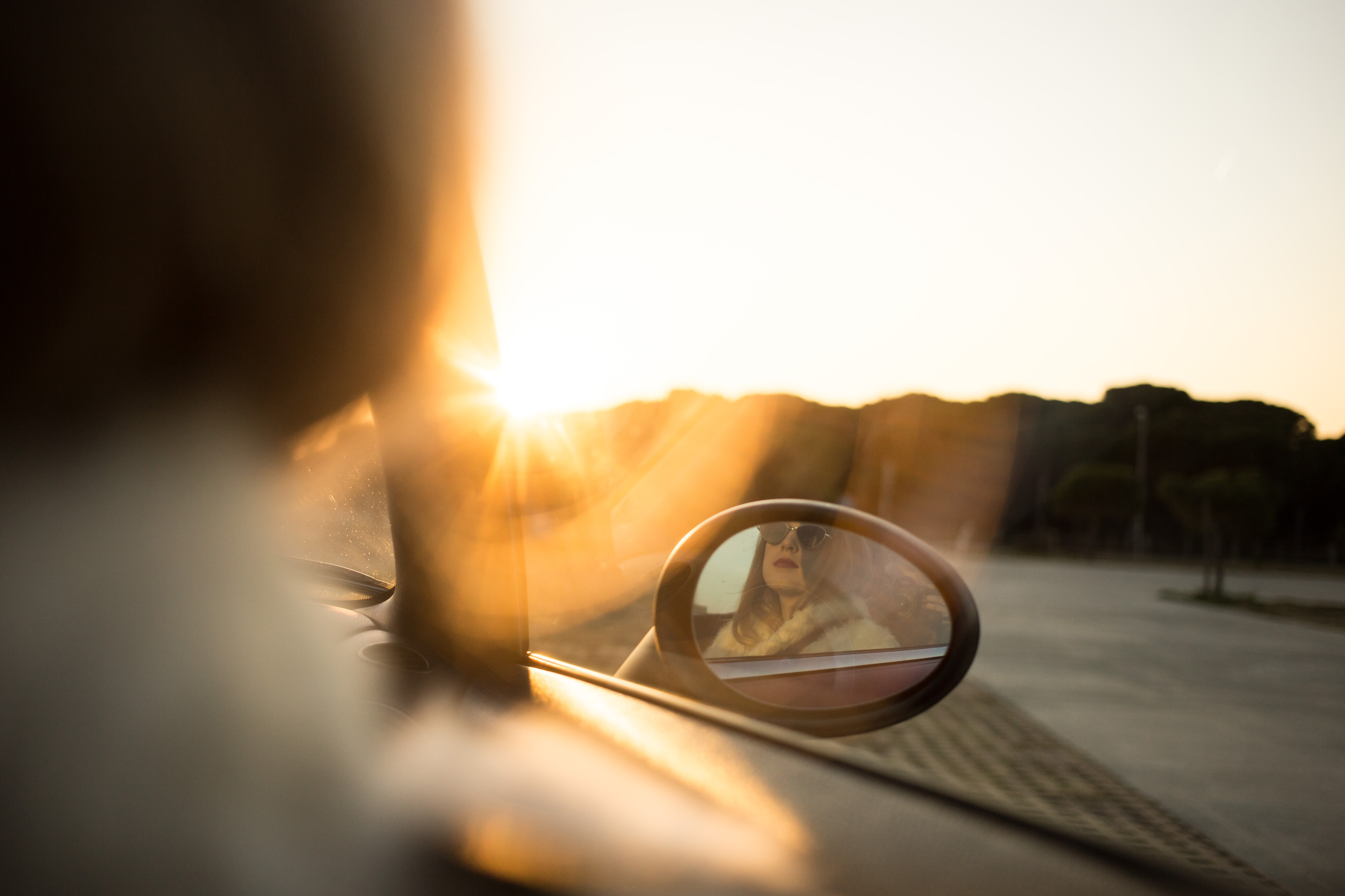 Reflection of young and fashionable woman in sideview mirror