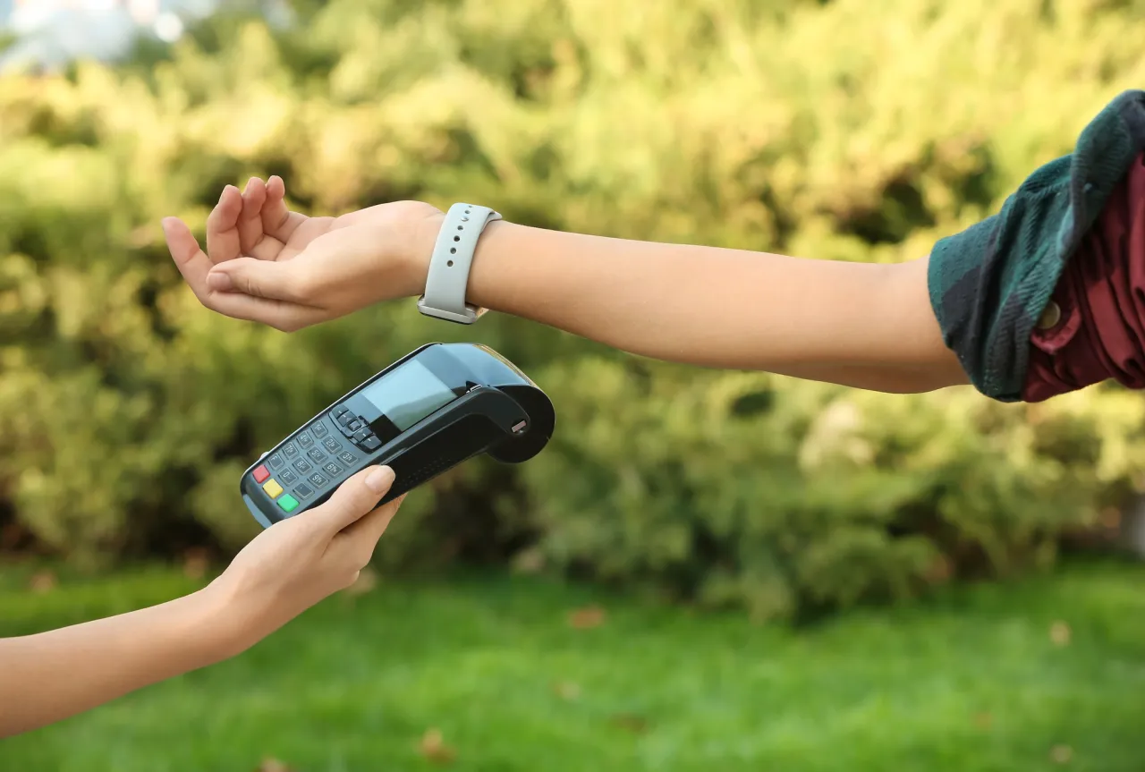 Woman using terminal for contactless payment stock image