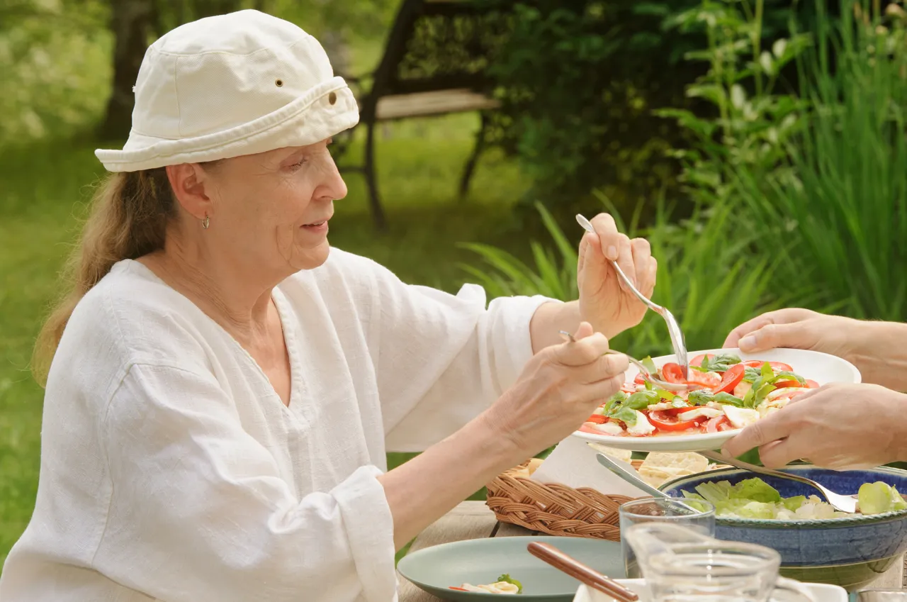 Senior woman eating outdoors stock photo