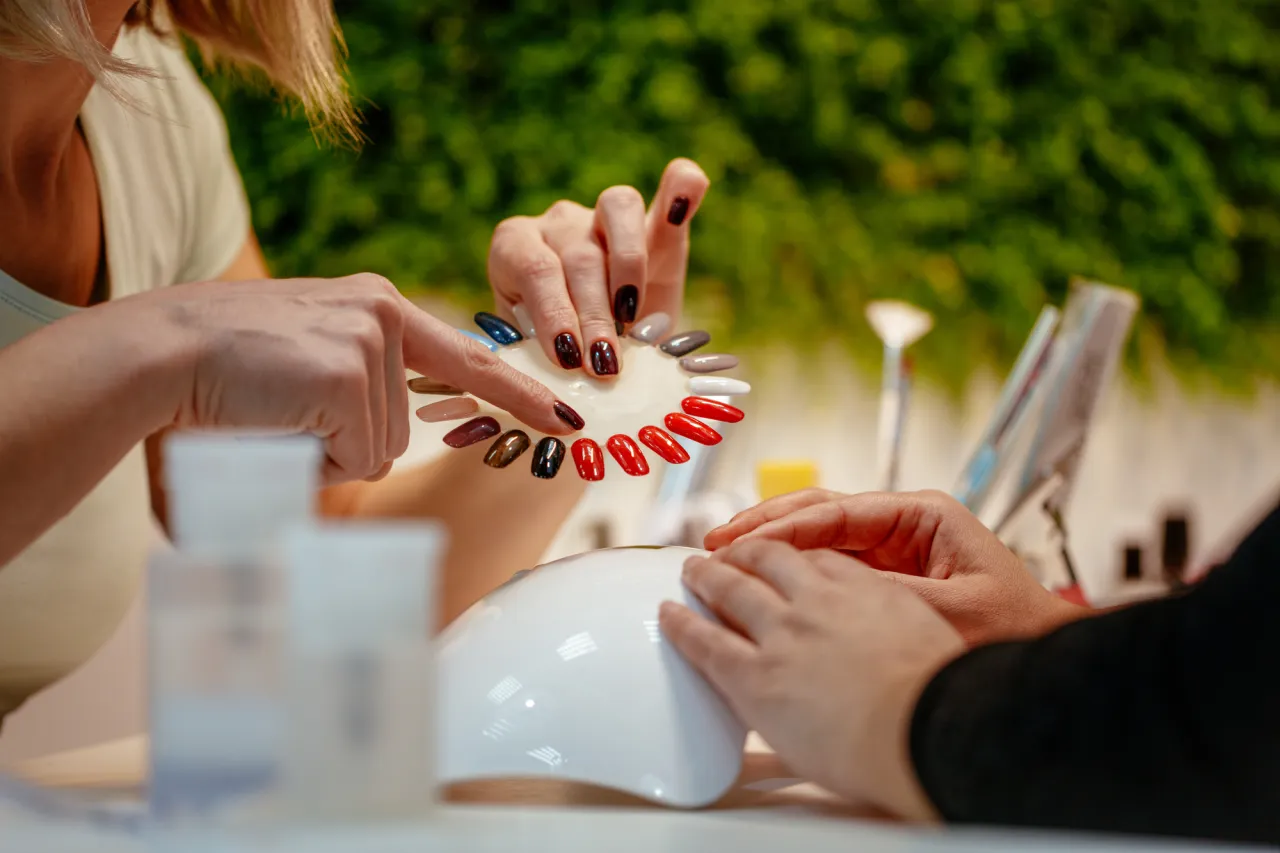 Close-up of woman choosing colours nails at the beauty salon