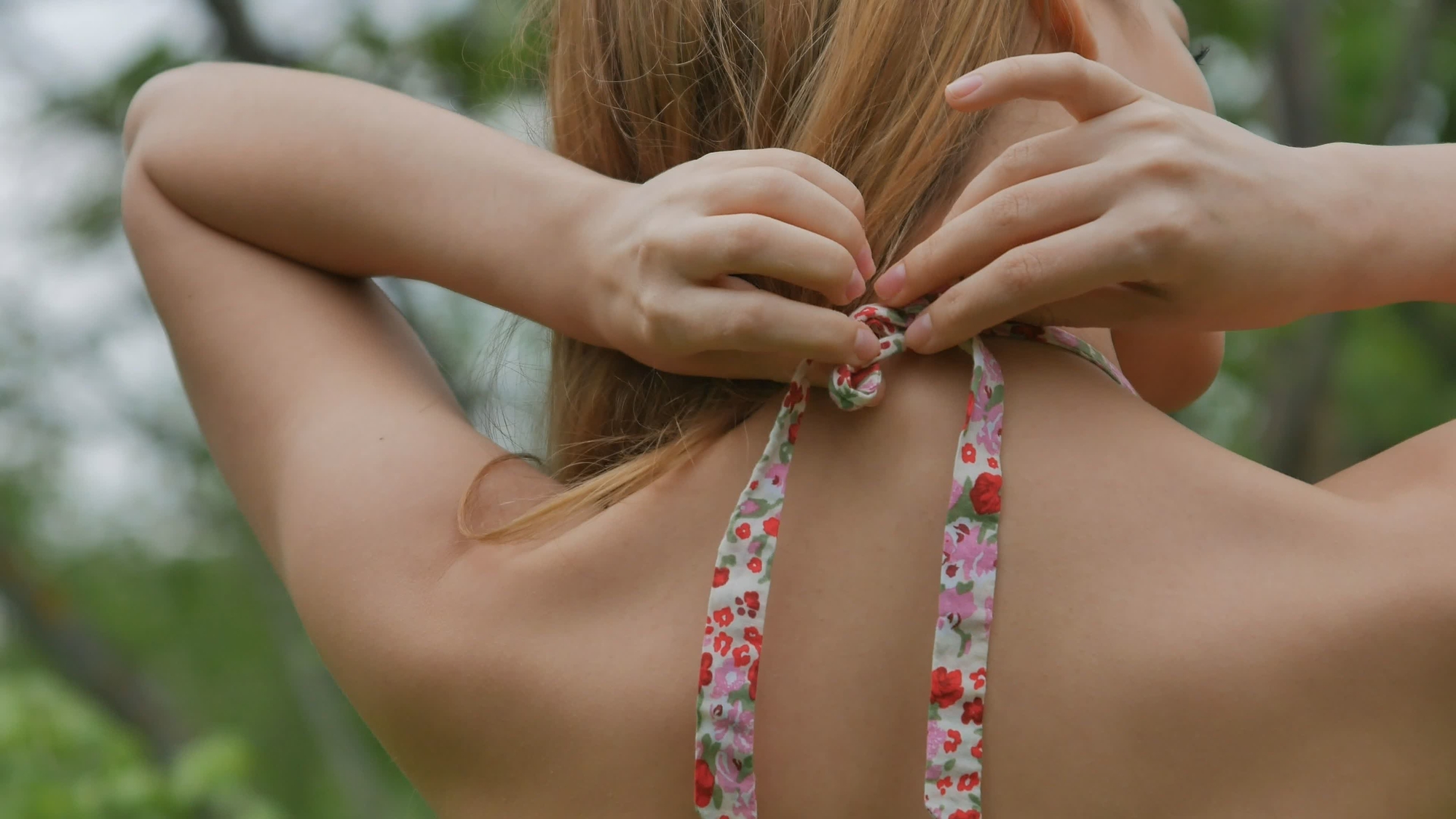 girl tying braid for clothes in the neck close up rear view