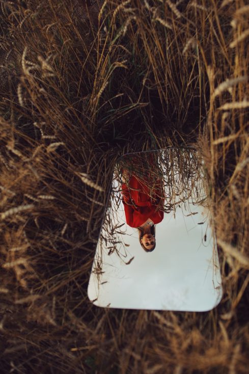 stock photo of woman in red dress in the mirror reflection 