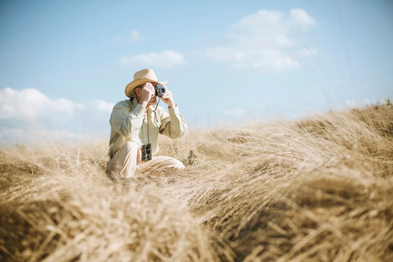 stock photo Senior safari man in the field taking picture