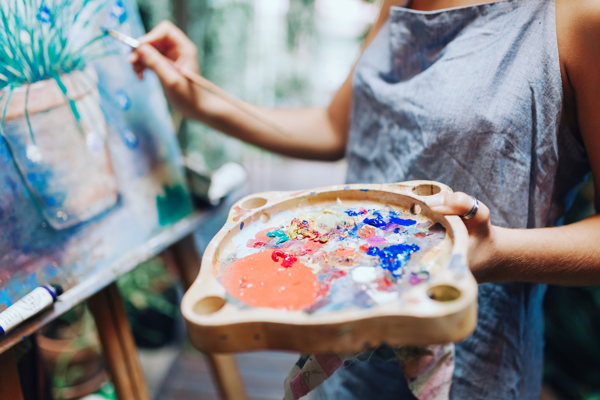 Indoor shot of professional female artist painting on canvas