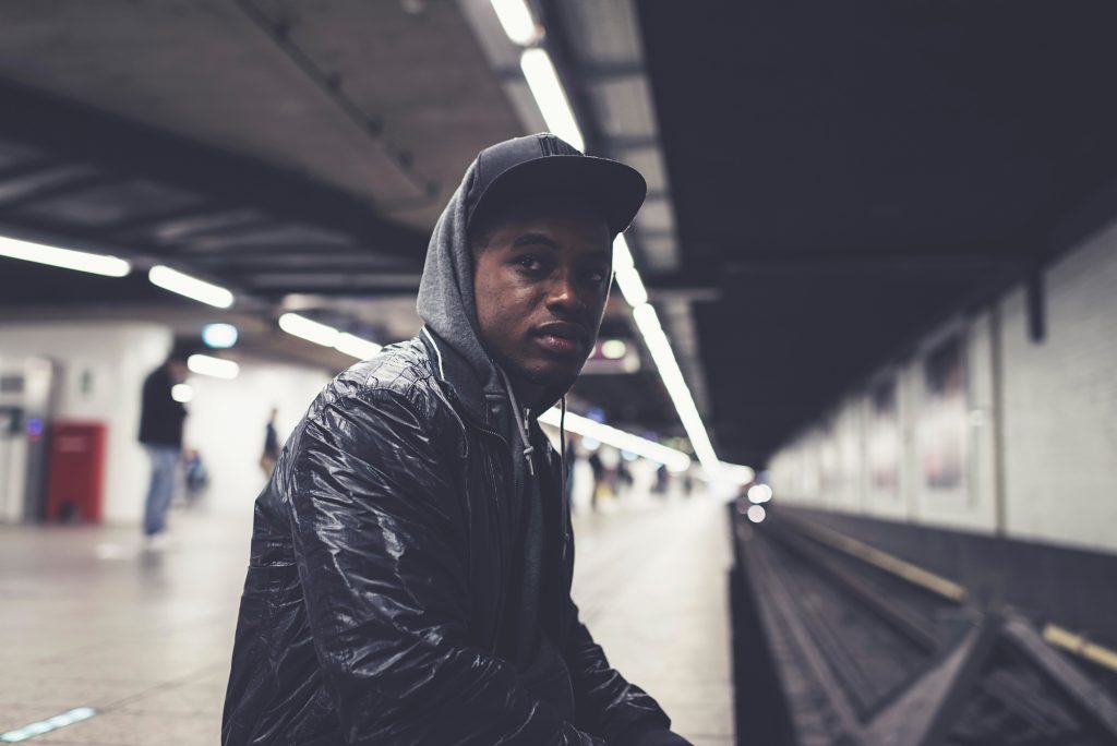 Urban fashion afro man sitting stock image