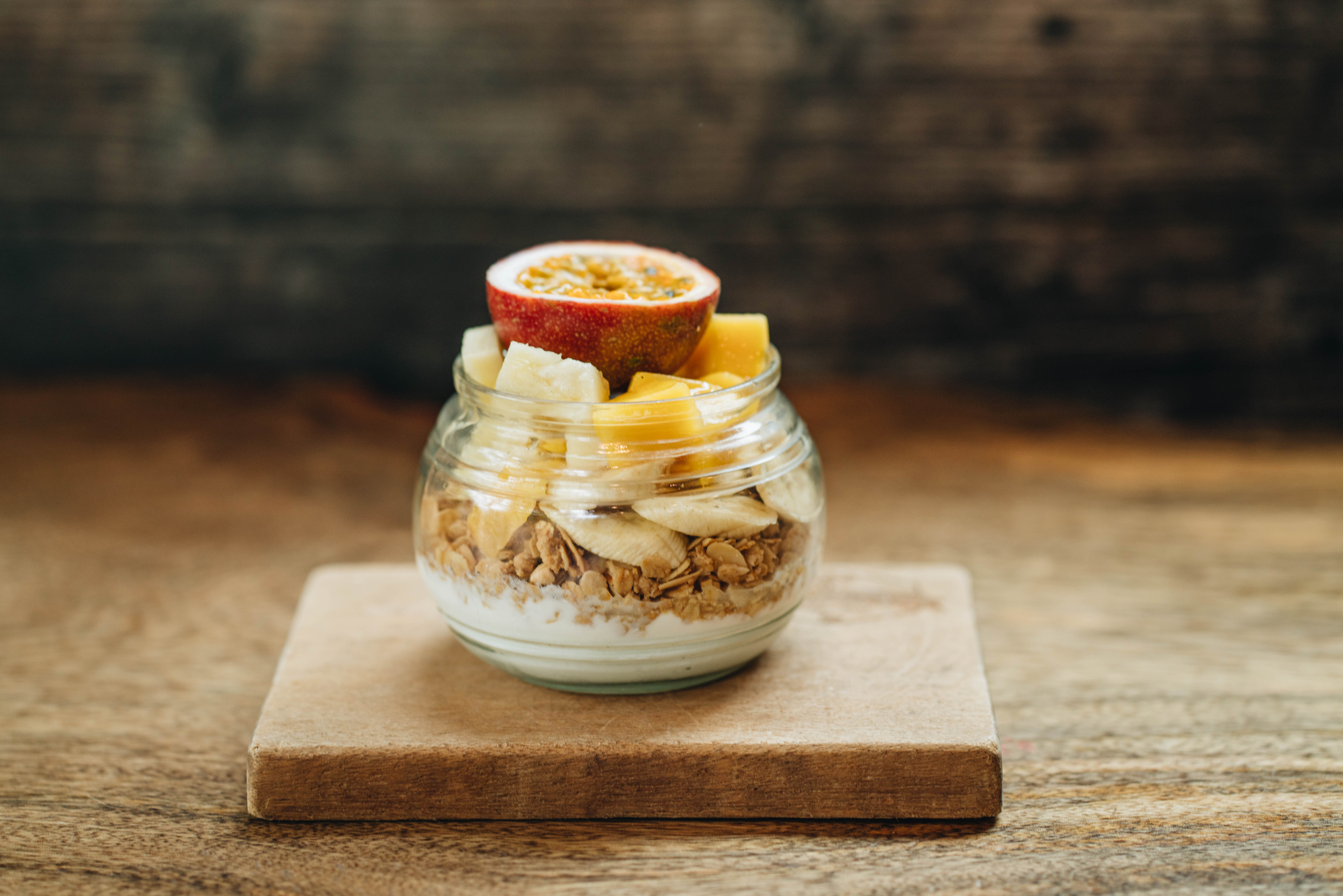 stock photo Muesli with yoghurt and tropical fruit at wooden background