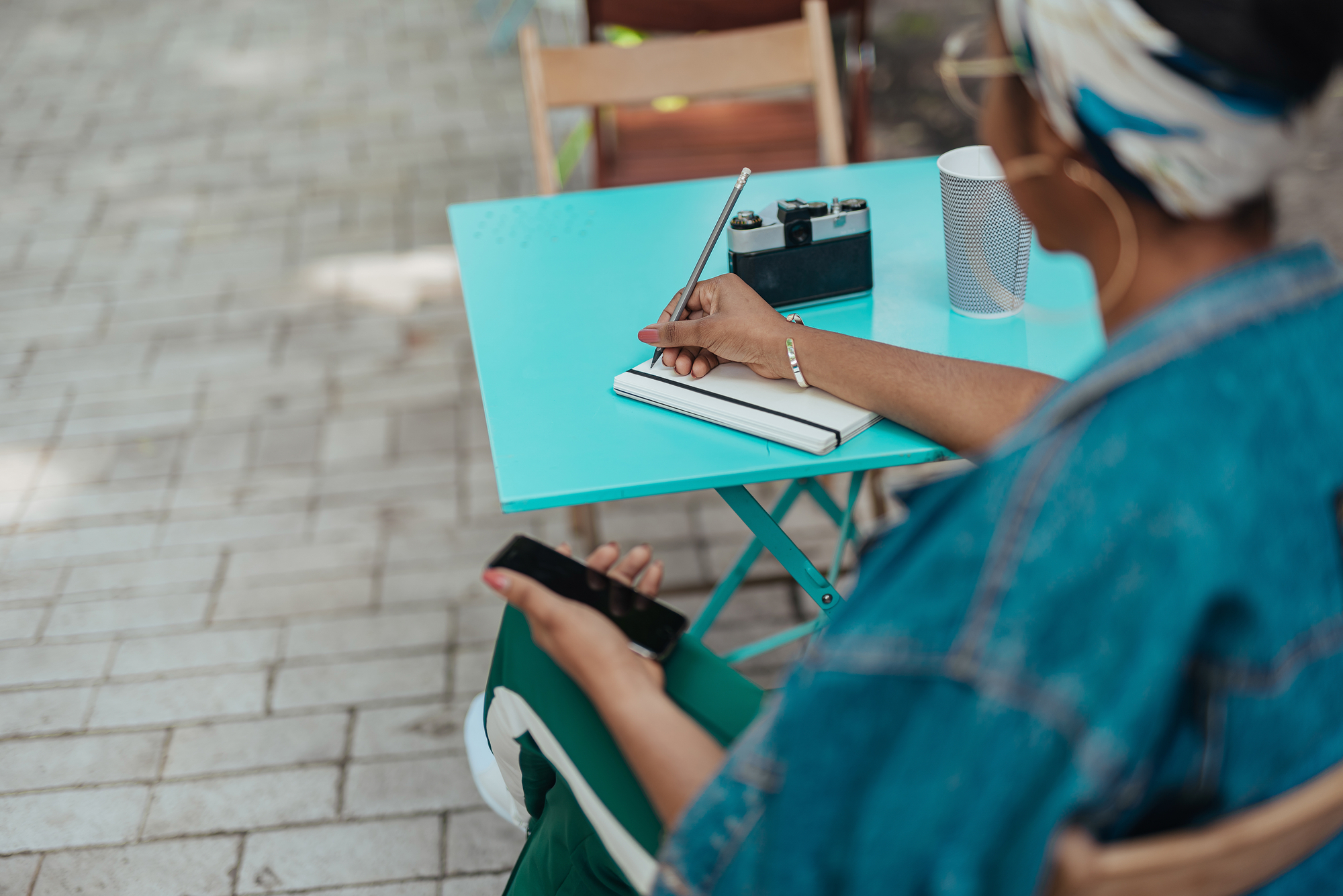 African american female sitting on terrace with notepad stock photo