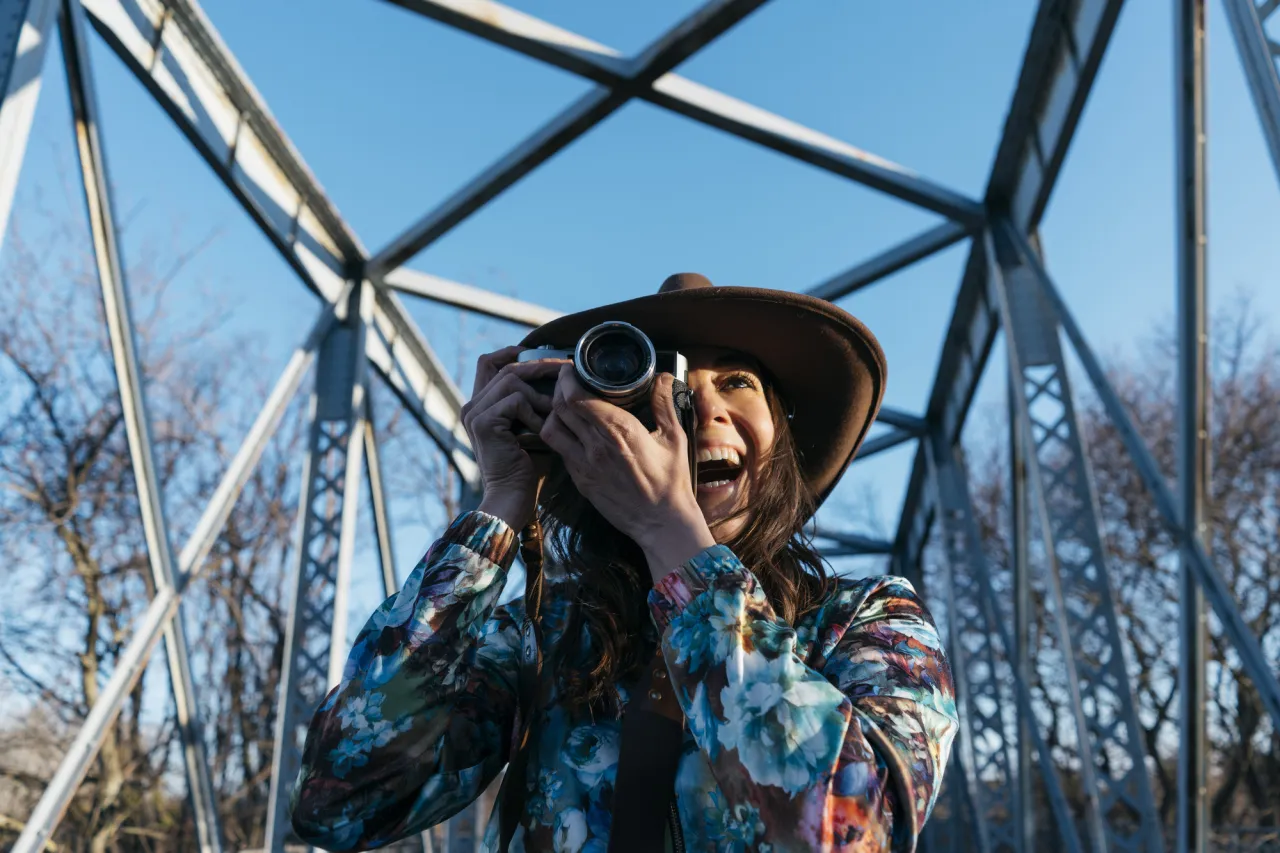 Smiling young woman using camera stock photo