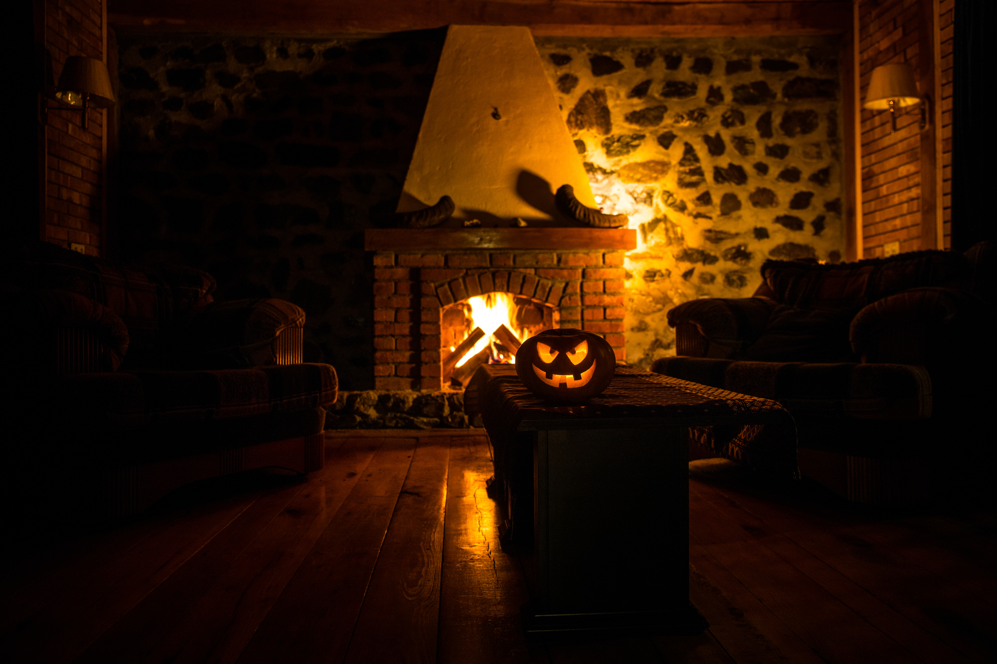 Creepy Halloween pumpkin near a fireplace stock photo