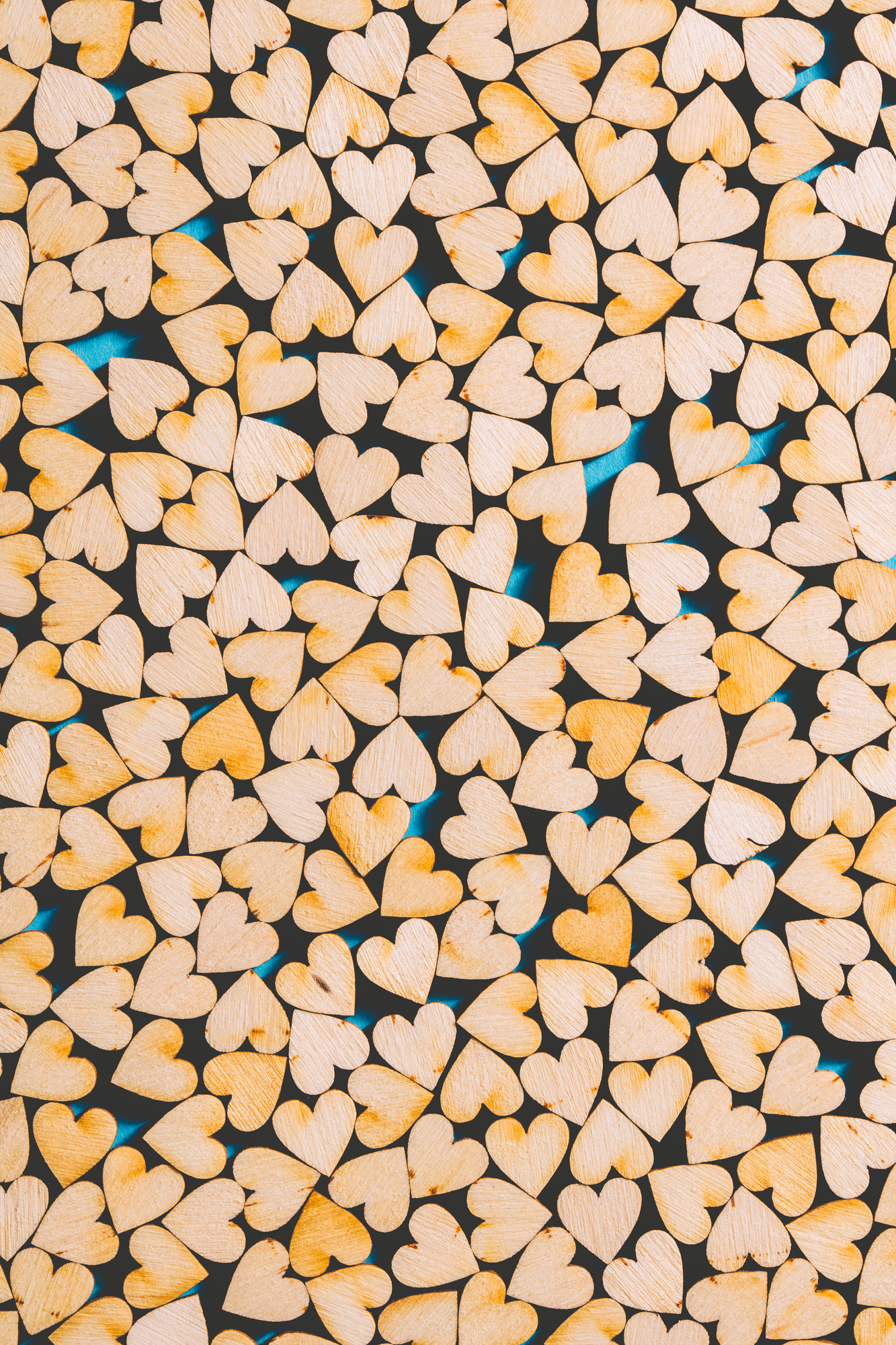 Little wooden hearts on blue background.