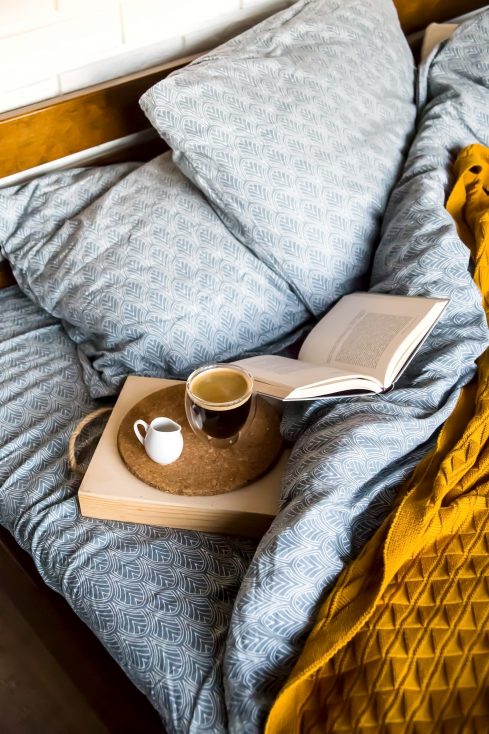 Café preto em uma xícara transparente na cama