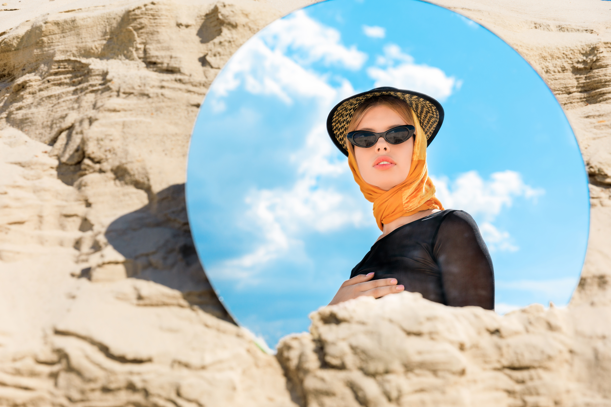 Round mirror with reflection of beautiful stylish model - stock photography portrait