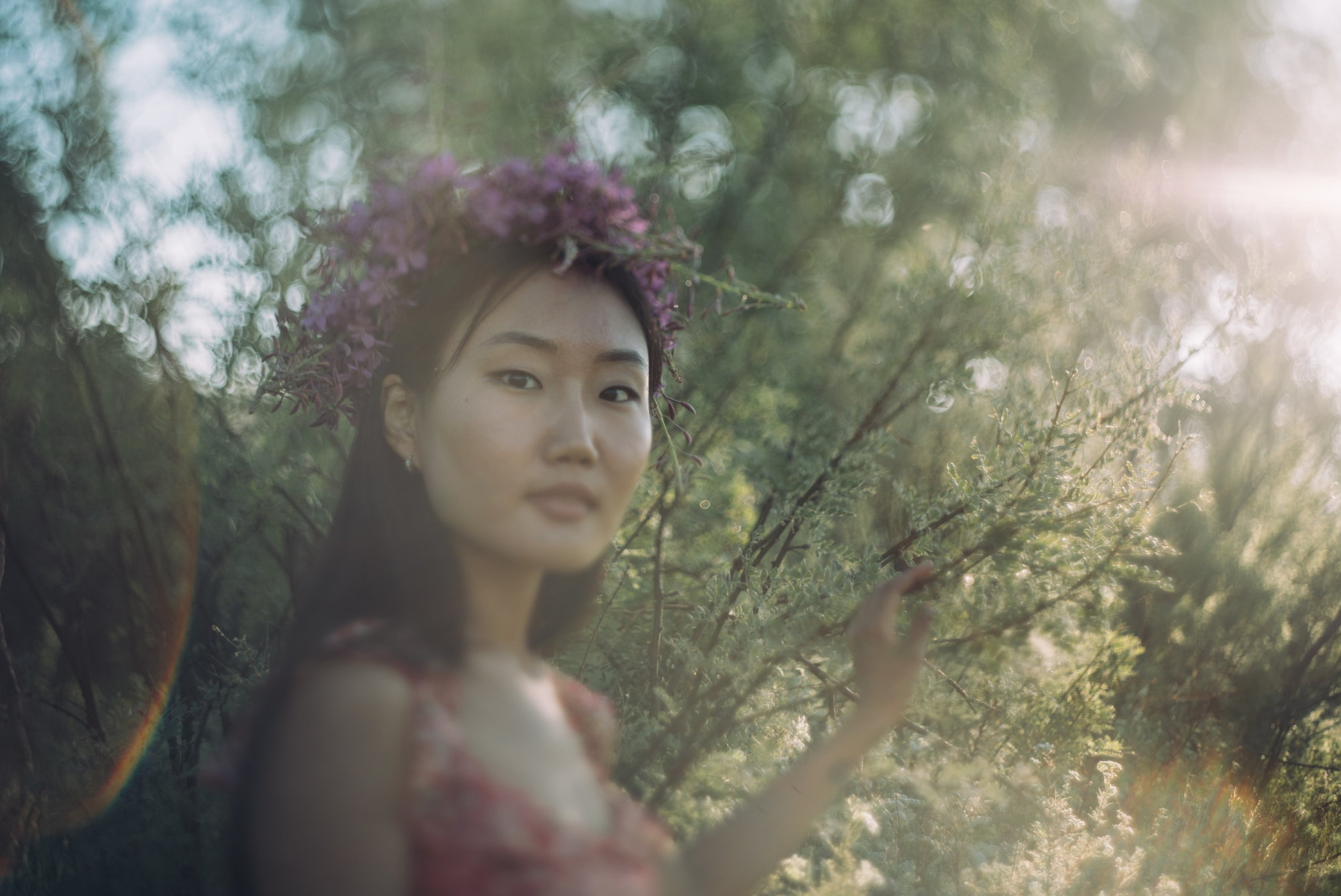 Happy young woman in a wreath from wildflowers and grass - portrait photoshoot idea