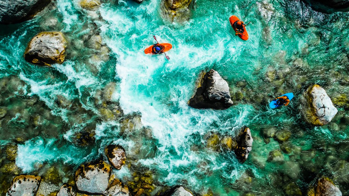 Emerald waters of Soca river, Slovenia, are the rafting paradise for adrenaline seekers and also nature lovers, aerial view.