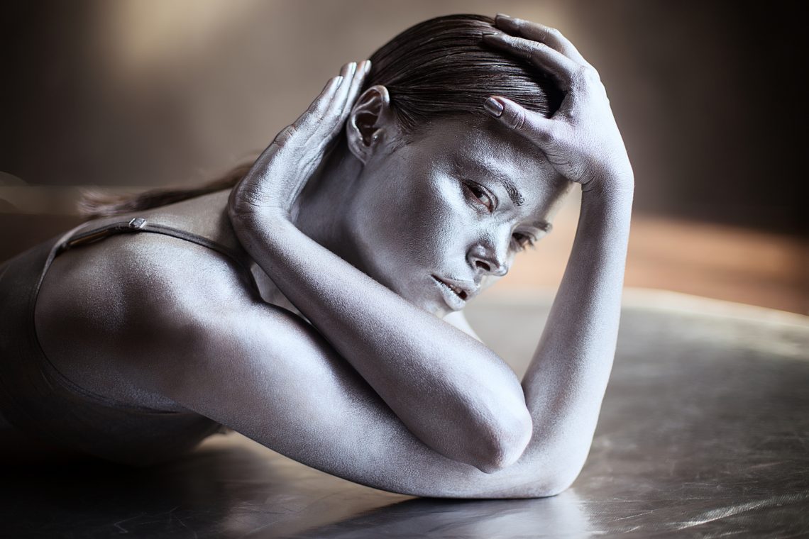 Attractive young girl covered in silver glitter