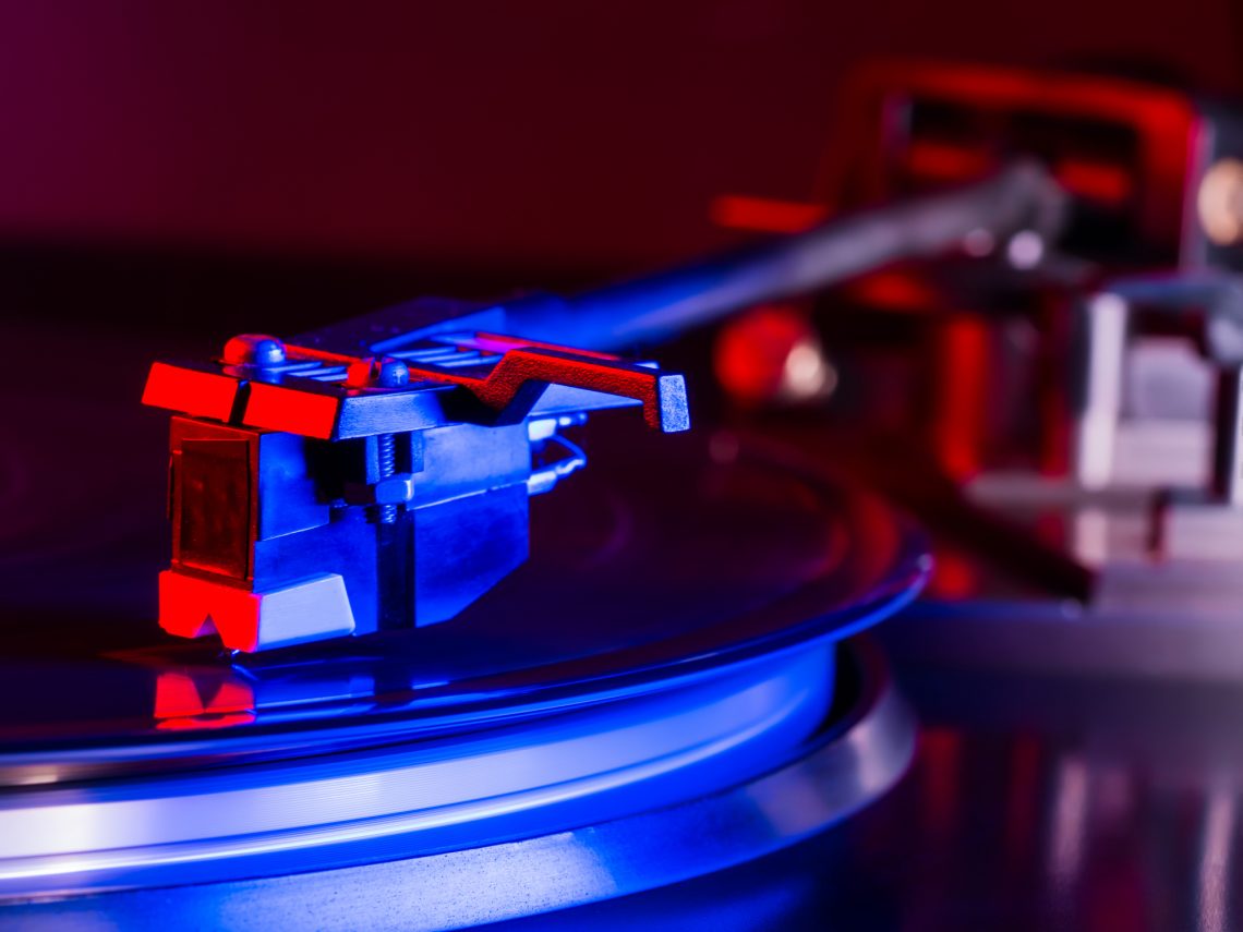 Vintage photo of Old Gramophone, playing a music. Neon light. Cinemagraph, retro record vinyl player. Record on turntable. Top view close up. Loop able