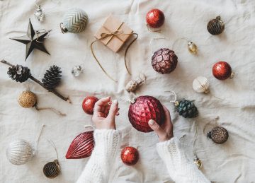 Christmas decoration toys and woman’s hands over linen cloth