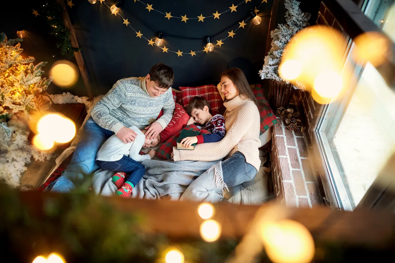 Mother and father with children playing at home on Christmas Day