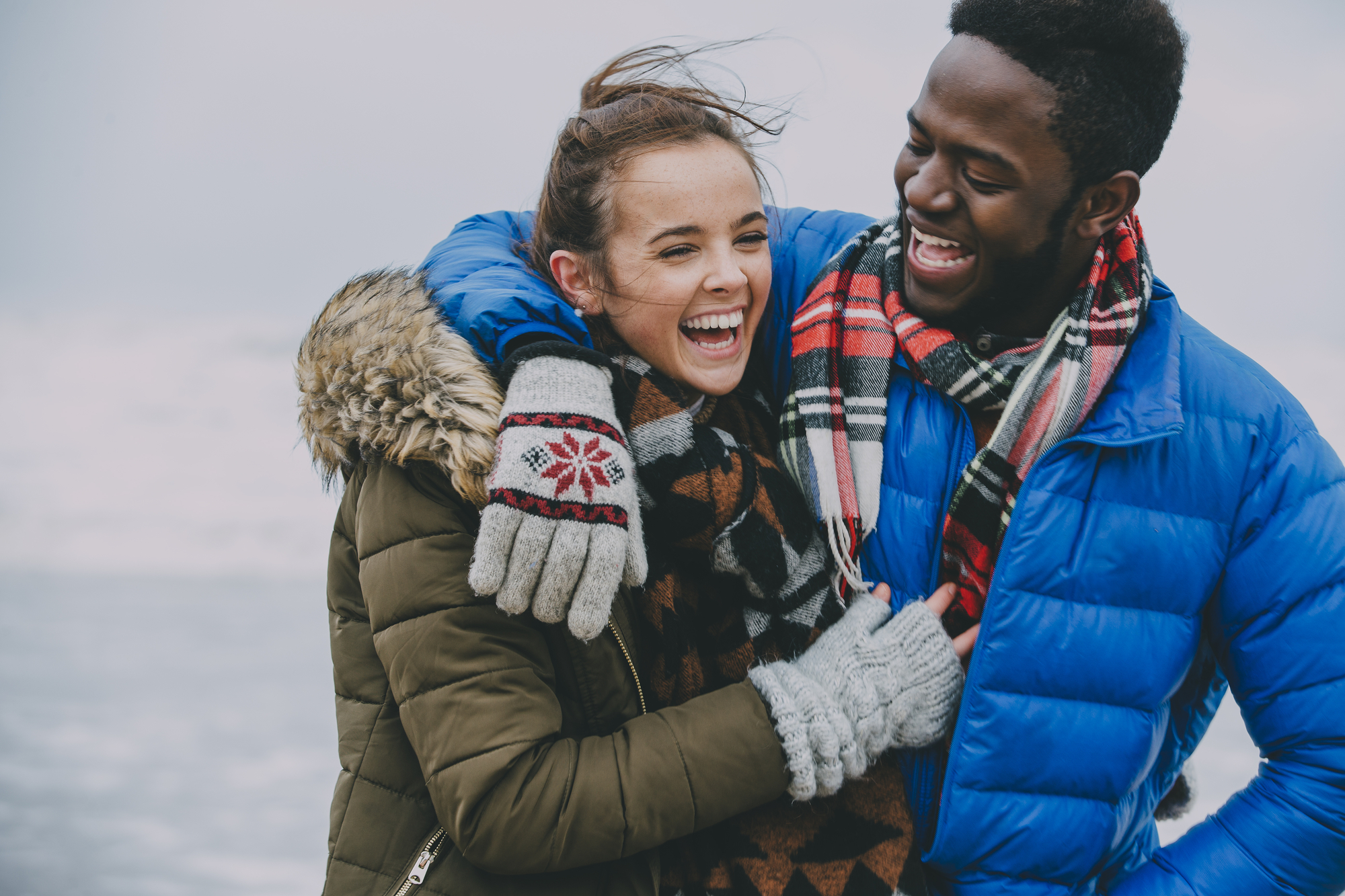 Young Couple Laughing On A Winter Beach