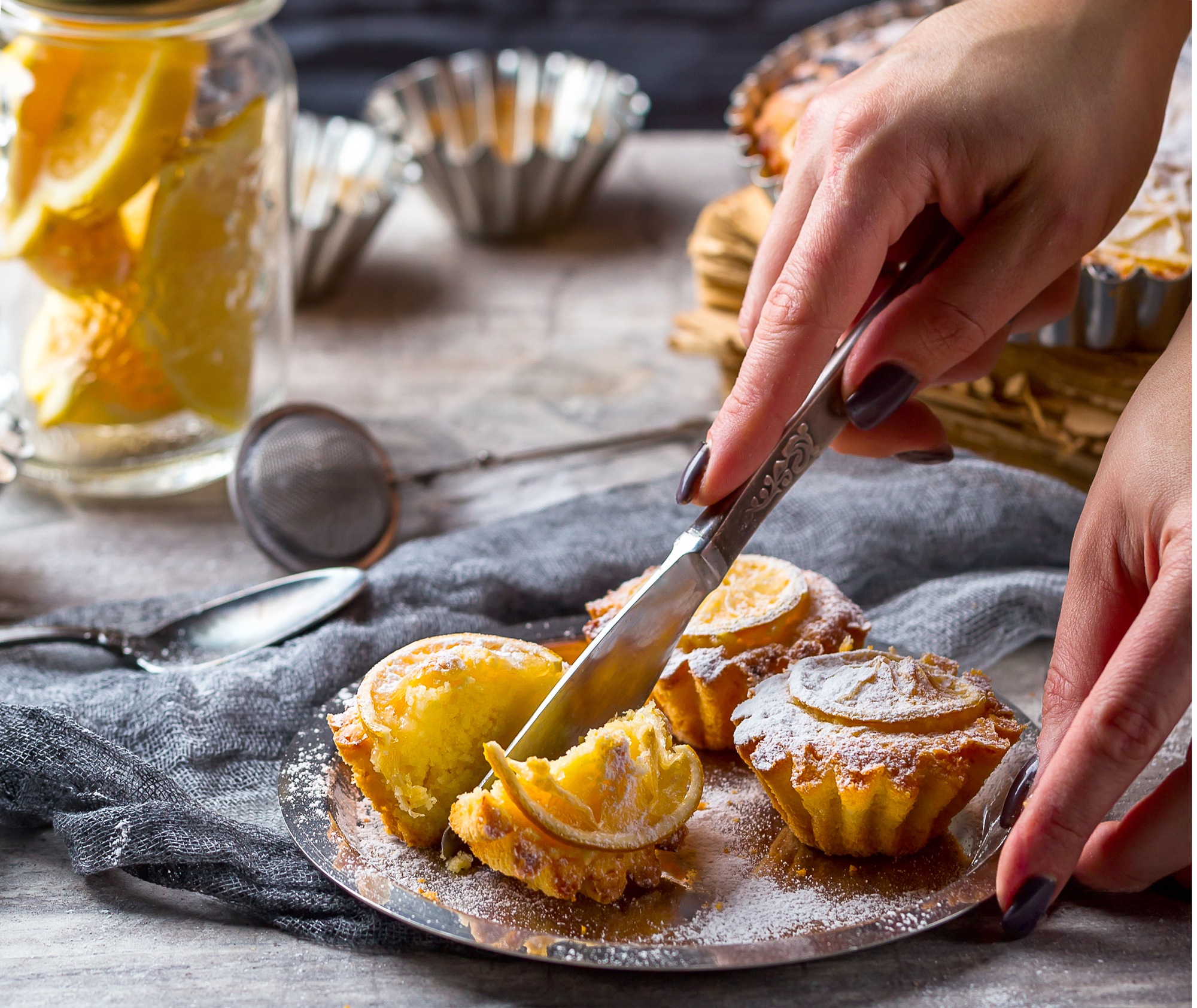 Hand with a knife cuts the lemon cupcake