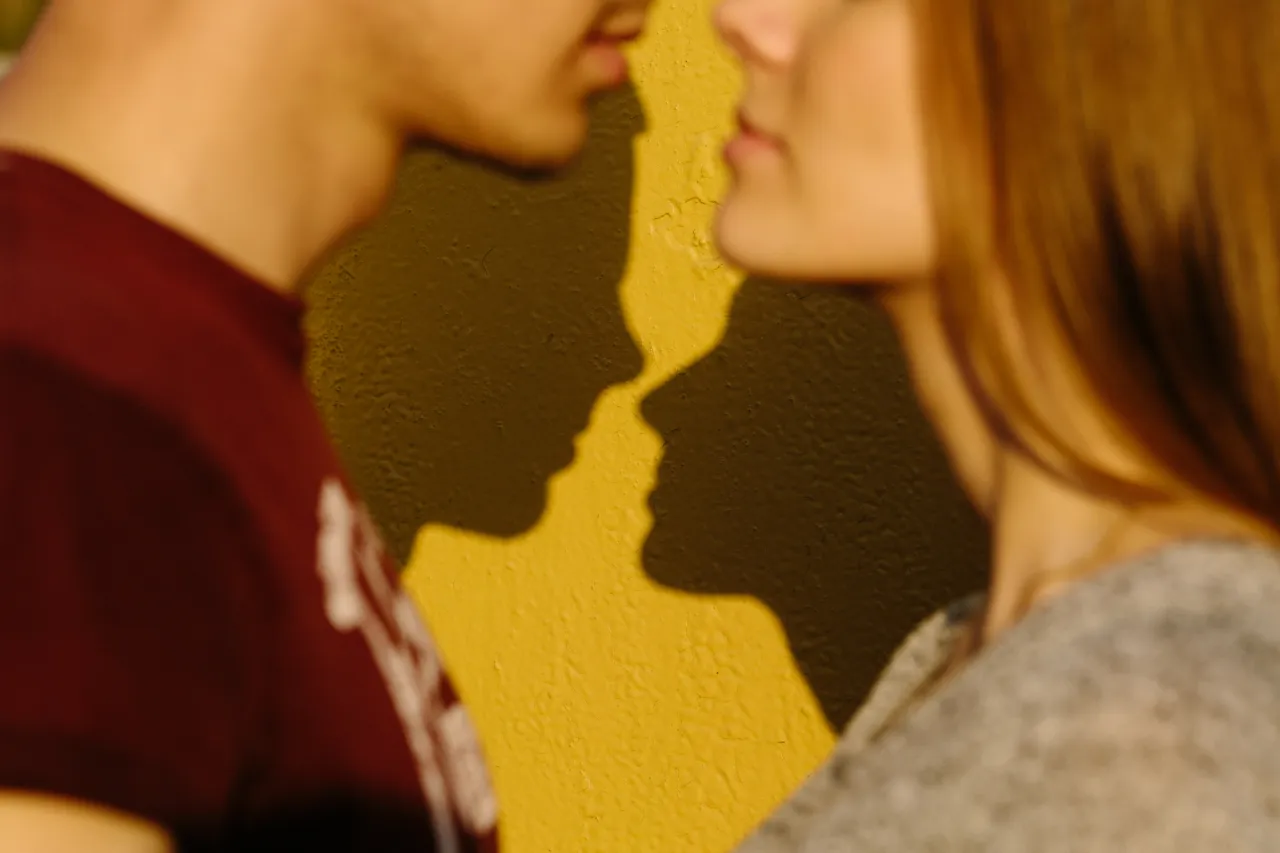 Silhouette couple in love with shadows on a yellow isolated background