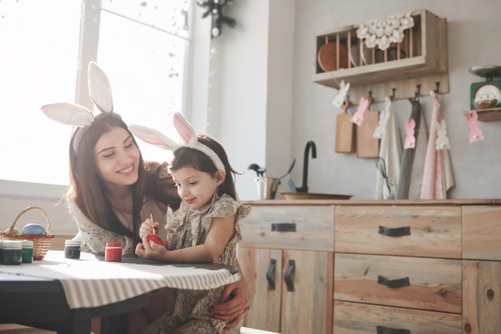 Good looking clean room. Mother and daughter in bunny ears at easter time have some fun in the kitchen at daytime