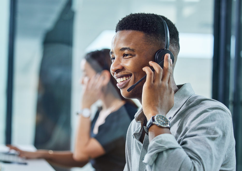 Photo of a young call centre agent on a call in an office.