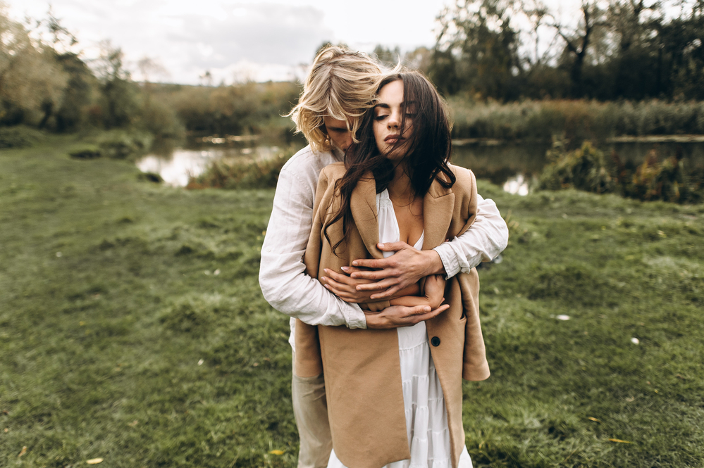 beautiful couple dressed in boho style walking in the sunny forest