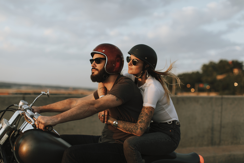 Biker couple riding down the road in the sunset