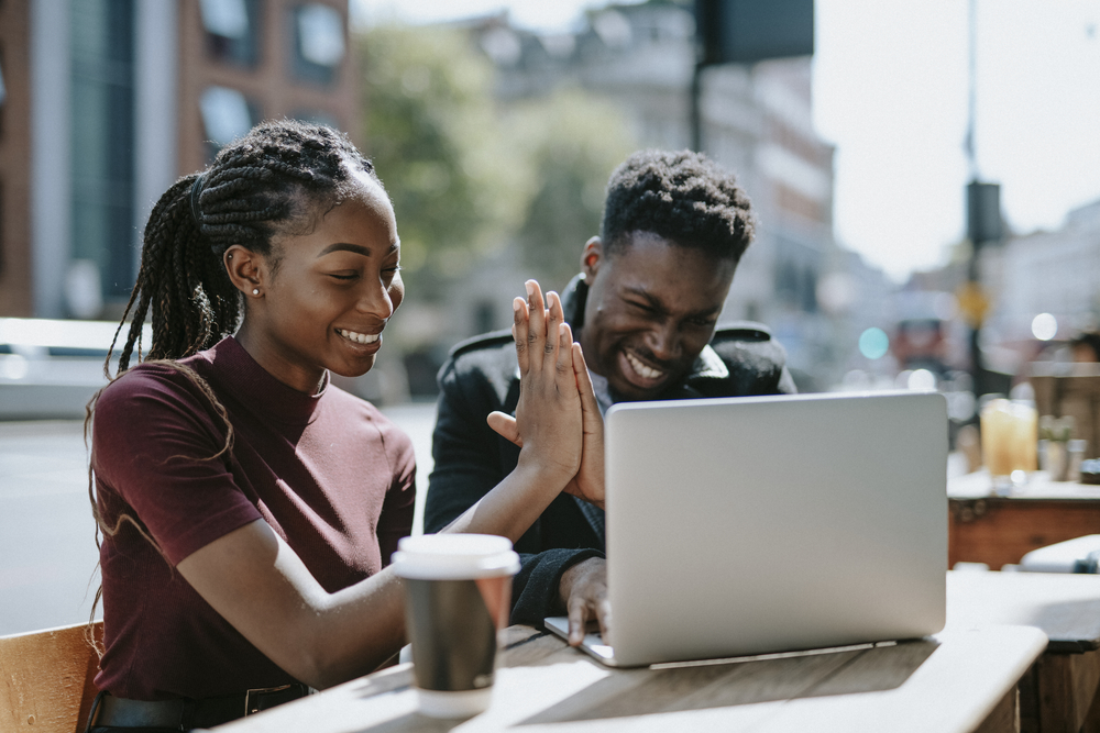 Photo black male and female colleagues sitting in front of a laptop during lunch 