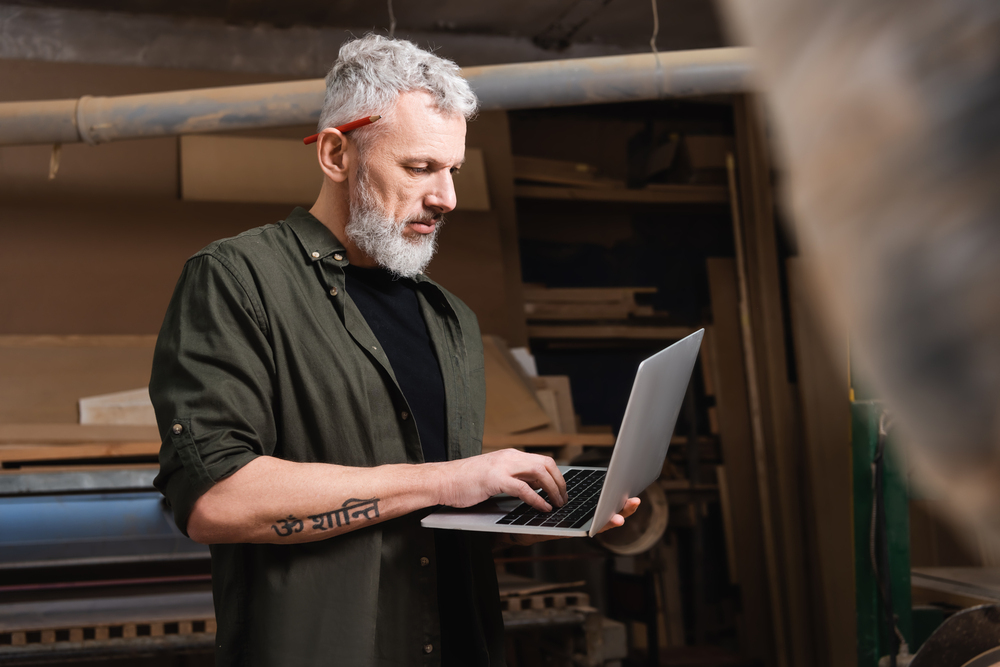 a senior man with a laptop