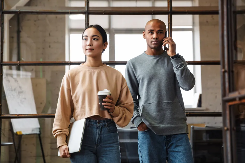 Image of multiethnic young female and male coworkers working together in office