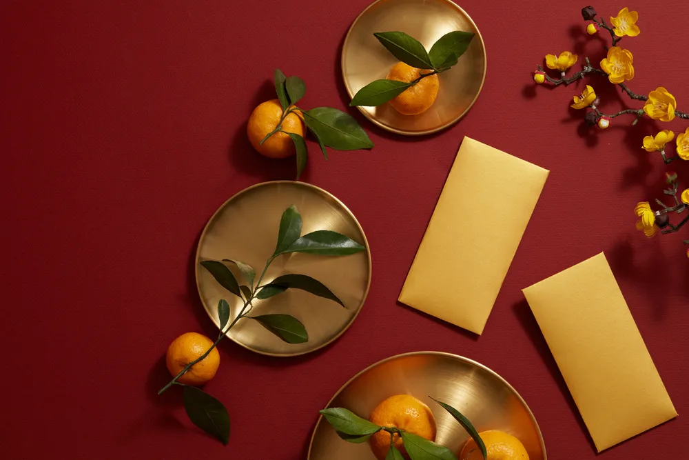 Chinese lunar new year with mandarin orange , flower and red pocket in red background , photography Tet holiday content , top view