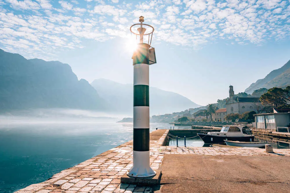 Black and white lighthouse in the sea. Prcanj, Kotor Bay, Montenegro.