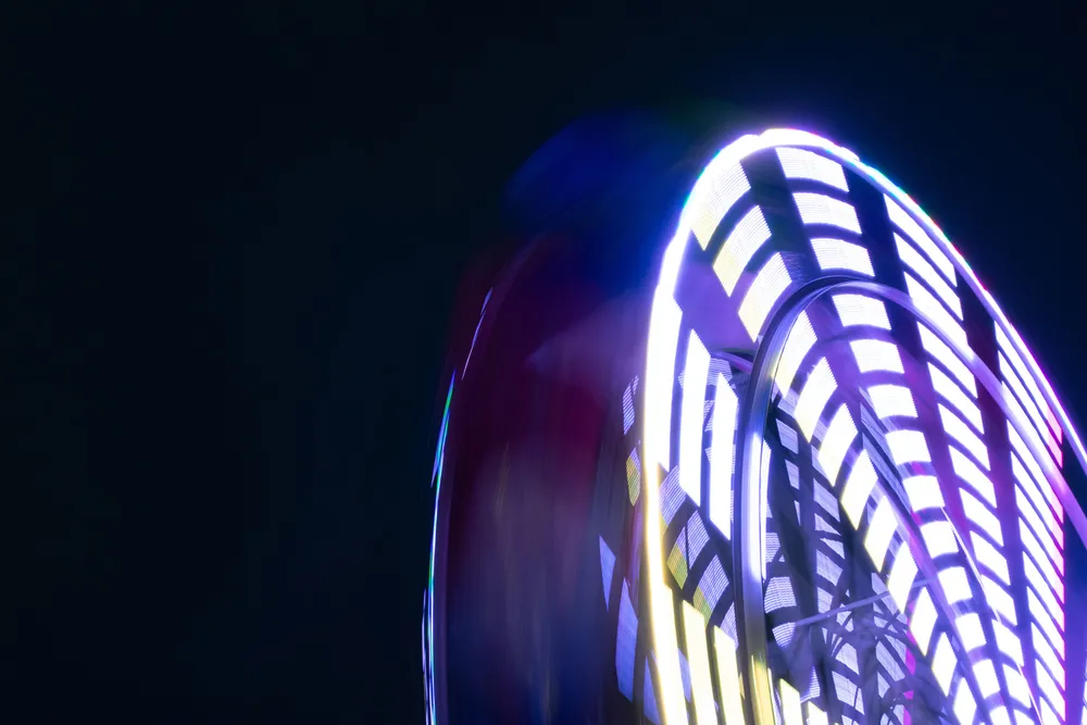 A long exposure shot of an illuminated Ferris wheel at night