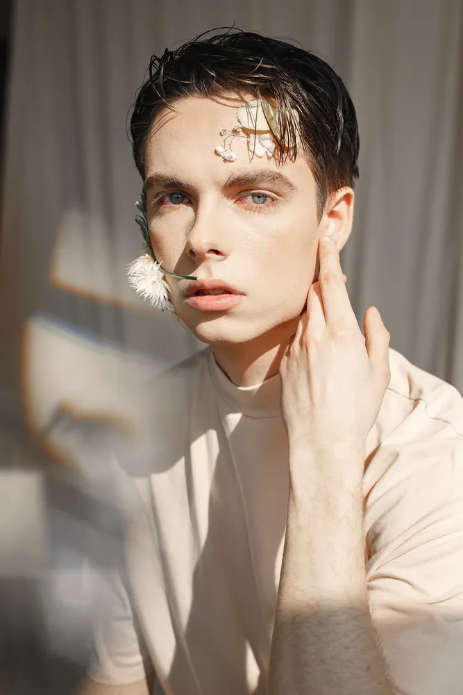 Emotional portrait of a guy with flowers on his face — Photo 